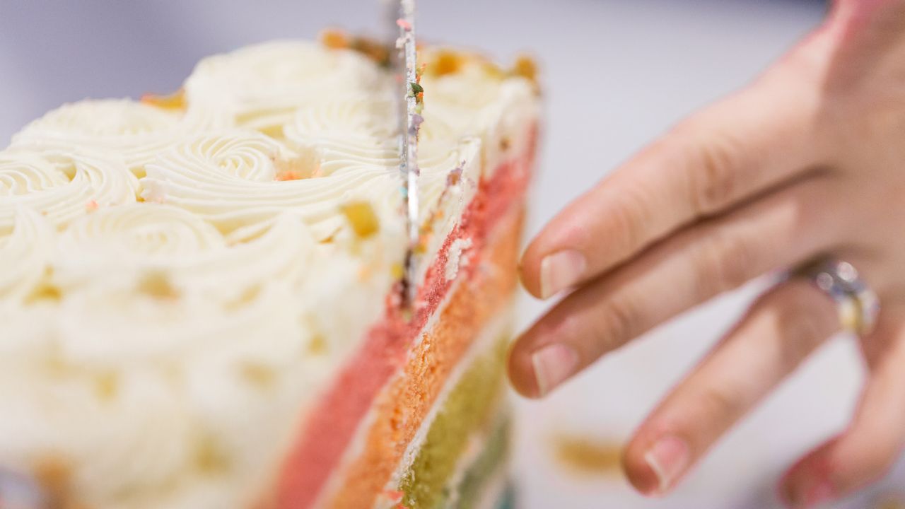 Hand cutting a layered cake with a knife
